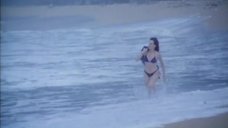Женщина в купальнике бежит по пляжу